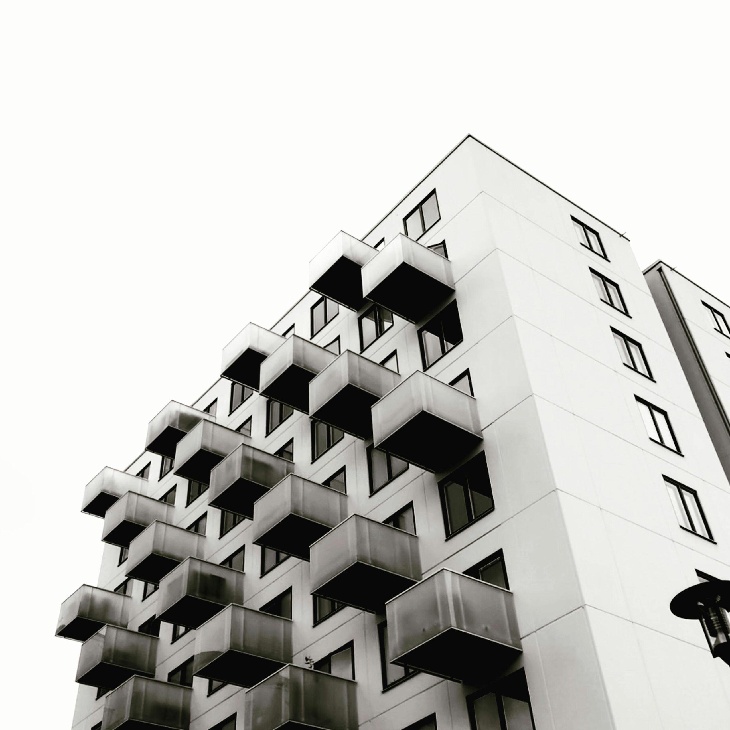 Low-angle view of a modern building with unique geometric balconies in Stigberget, Sweden.